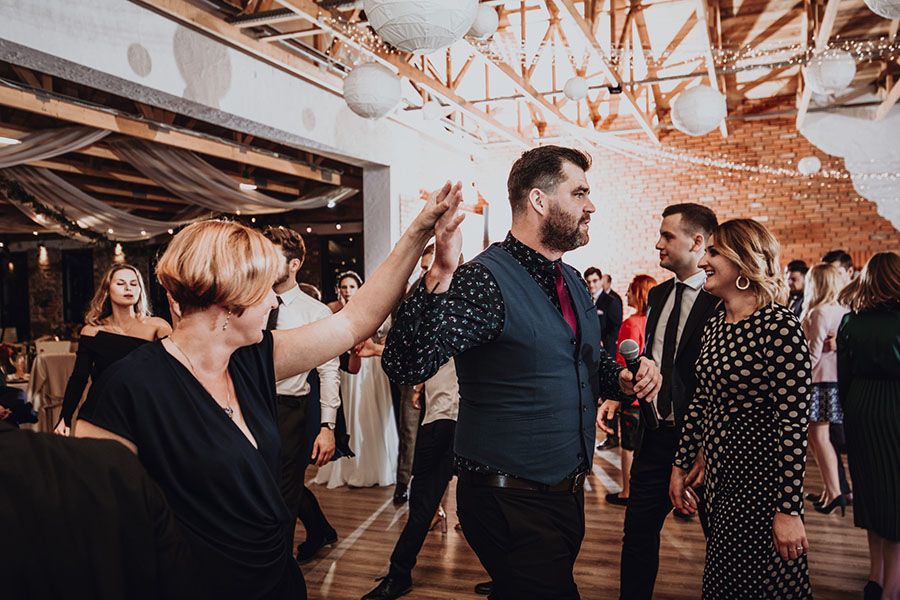 Konferansjer z firmy Zero Siedem prowadzący tradycyjny polski taniec na weselu. Wesele krok po kroku zamienia się w taneczną imprezę.