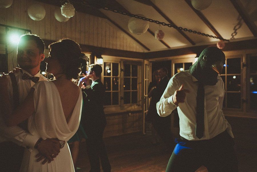 Para tańcząca na weselu, a obok niej mężczyzna w masce ptaka.